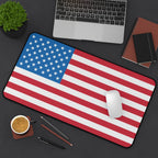 American flag mouse pad on a desk with a laptop, coffee, and office supplies.