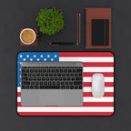 Laptop with American flag design on a dark surface with office items.