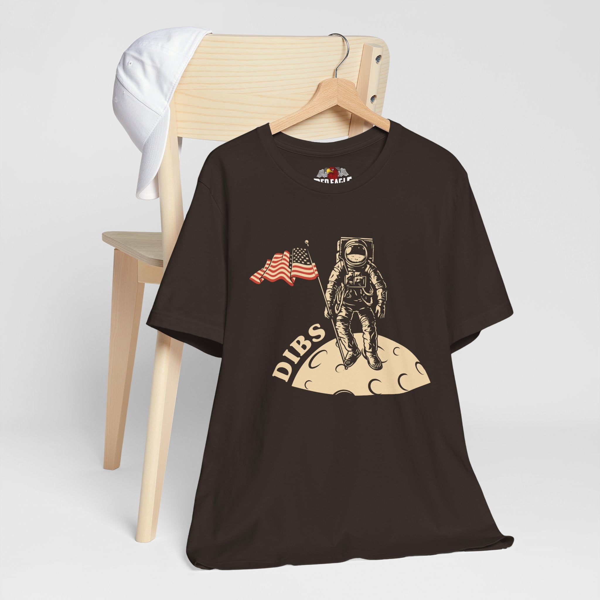 Brown t-shirt with astronaut graphic and 'DIBS' text on a white background