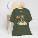 Military Green t-shirt with astronaut graphic and 'DIBS' text on a wooden chair.