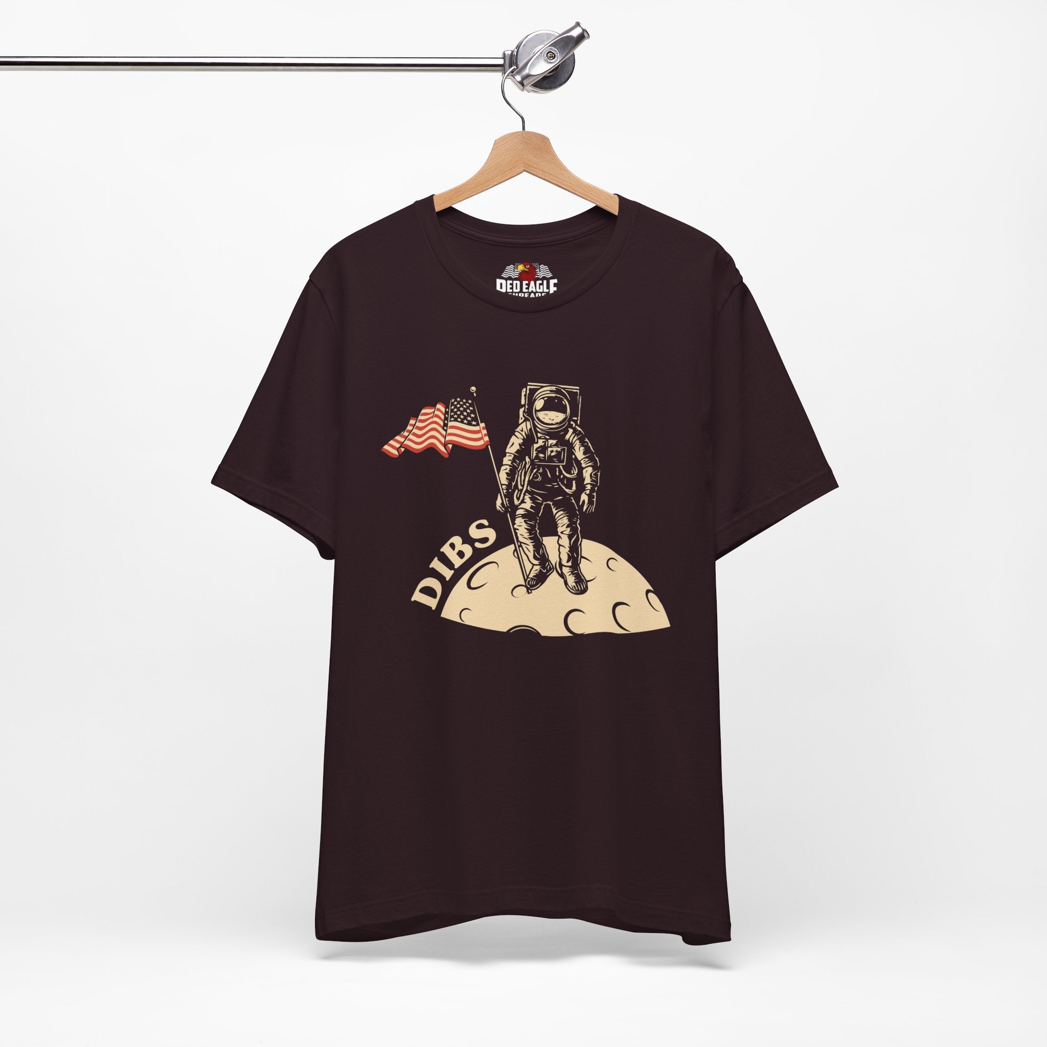 Oxblood Black t-shirt with astronaut graphic and 'DIBS' text on a hanger against a white background