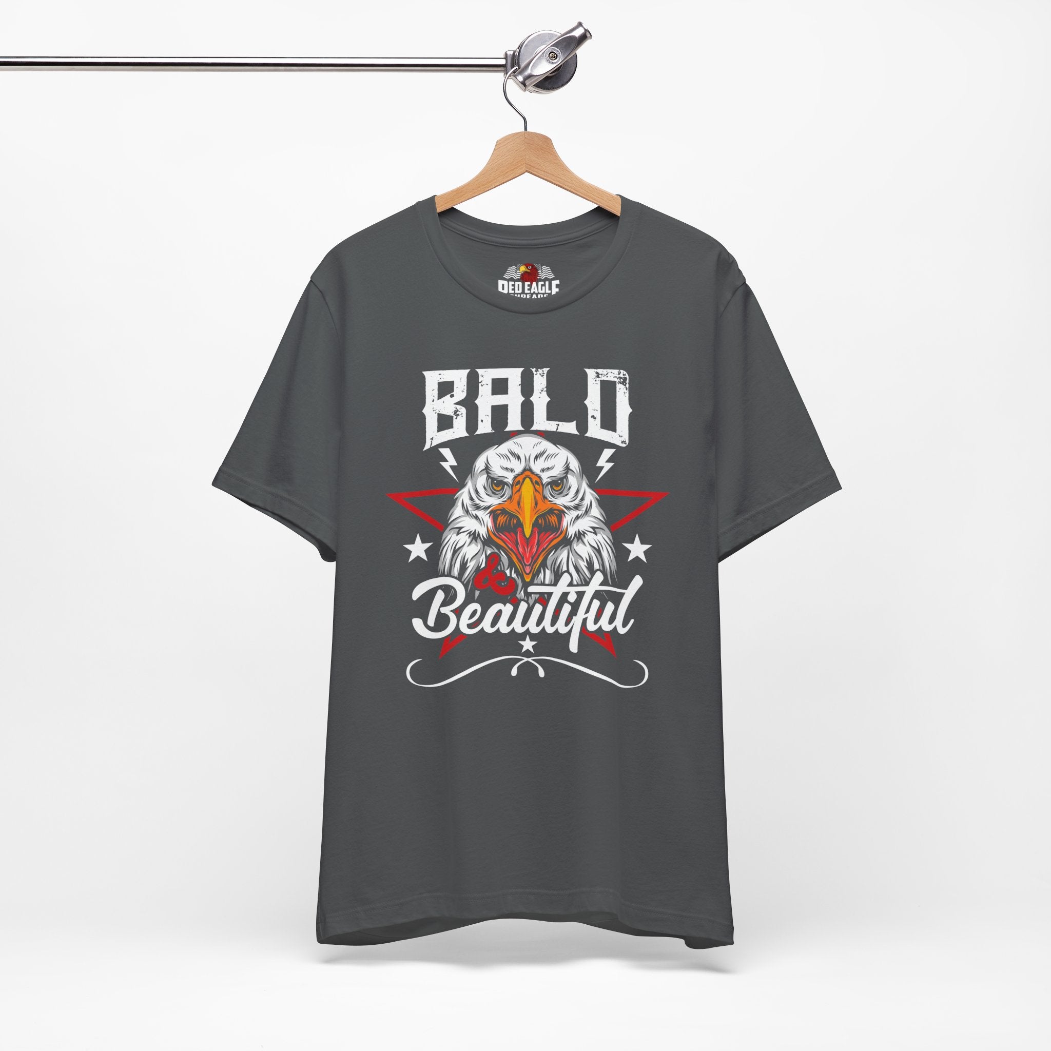 Gray t-shirt with an eagle graphic and 'Bald is Beautiful' text on a hanger against a white background.