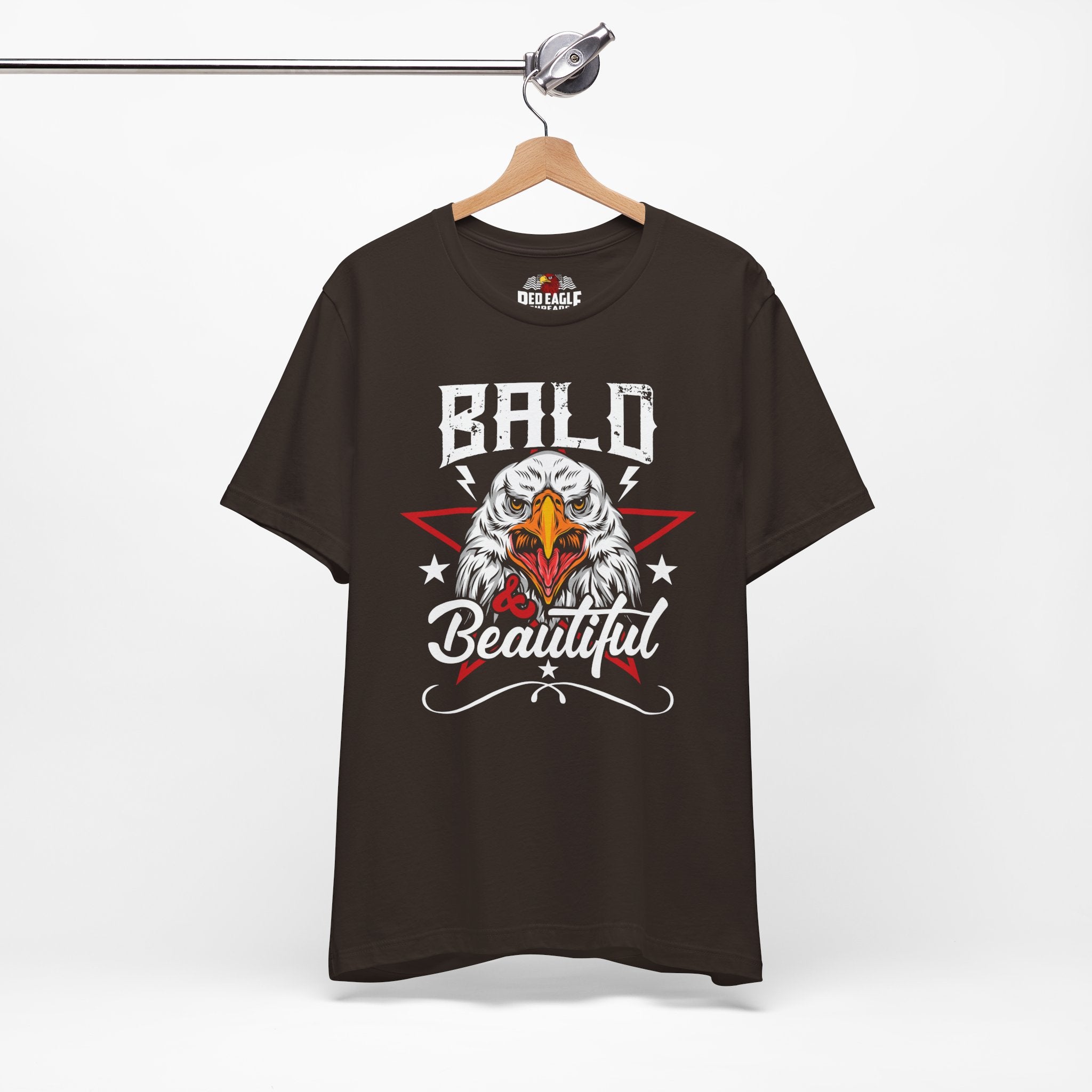 Brown t-shirt with bald eagle graphic and 'Bald is Beautiful' text on a hanger against a white background