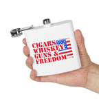 White flask with 'Cigars Whiskey Guns & Freedom' text and American flag design held by a hand on a white background