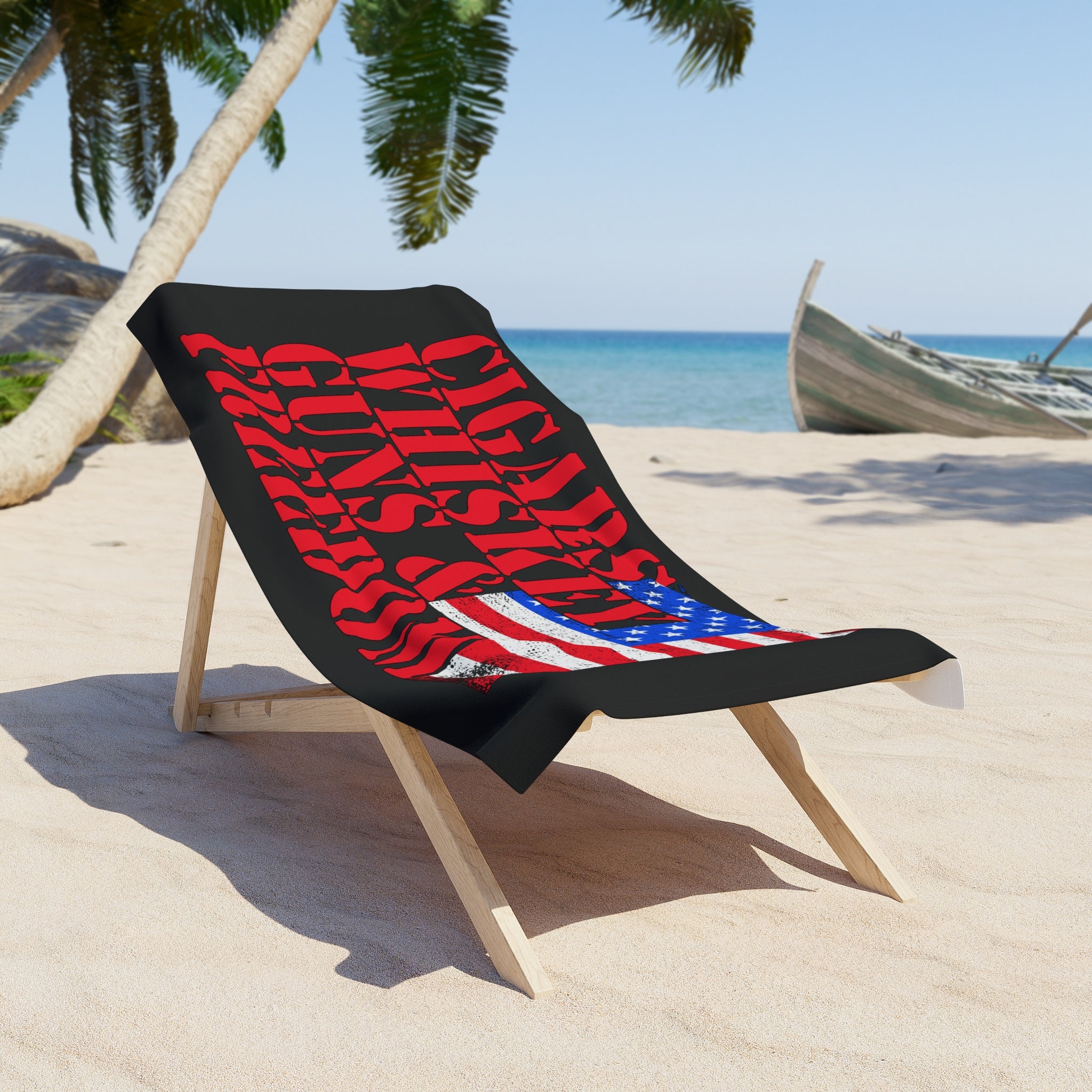 Beach chair with a towel featuring an American flag design on a sandy beach.
