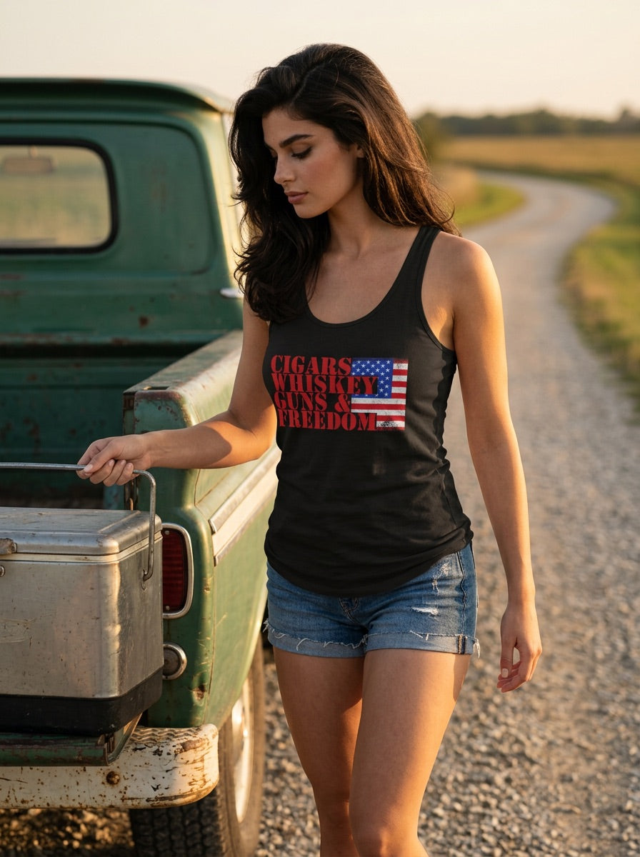 A woman stands on a gravel road beside a vintage green pickup truck, wearing a black racerback tank top with a red, white, and blue 'Cigars, Whiskey, and Freedom' graphic. The background shows a rural road stretching into the distance during golden hour. (AI Generated)