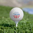 Golf ball with 'FREEDOM' text on a tee in grass