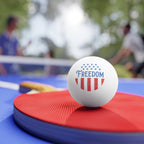 Ping pong ball with 'FREEDOM' text on a paddle, with a blurred background of people playing ping pong.