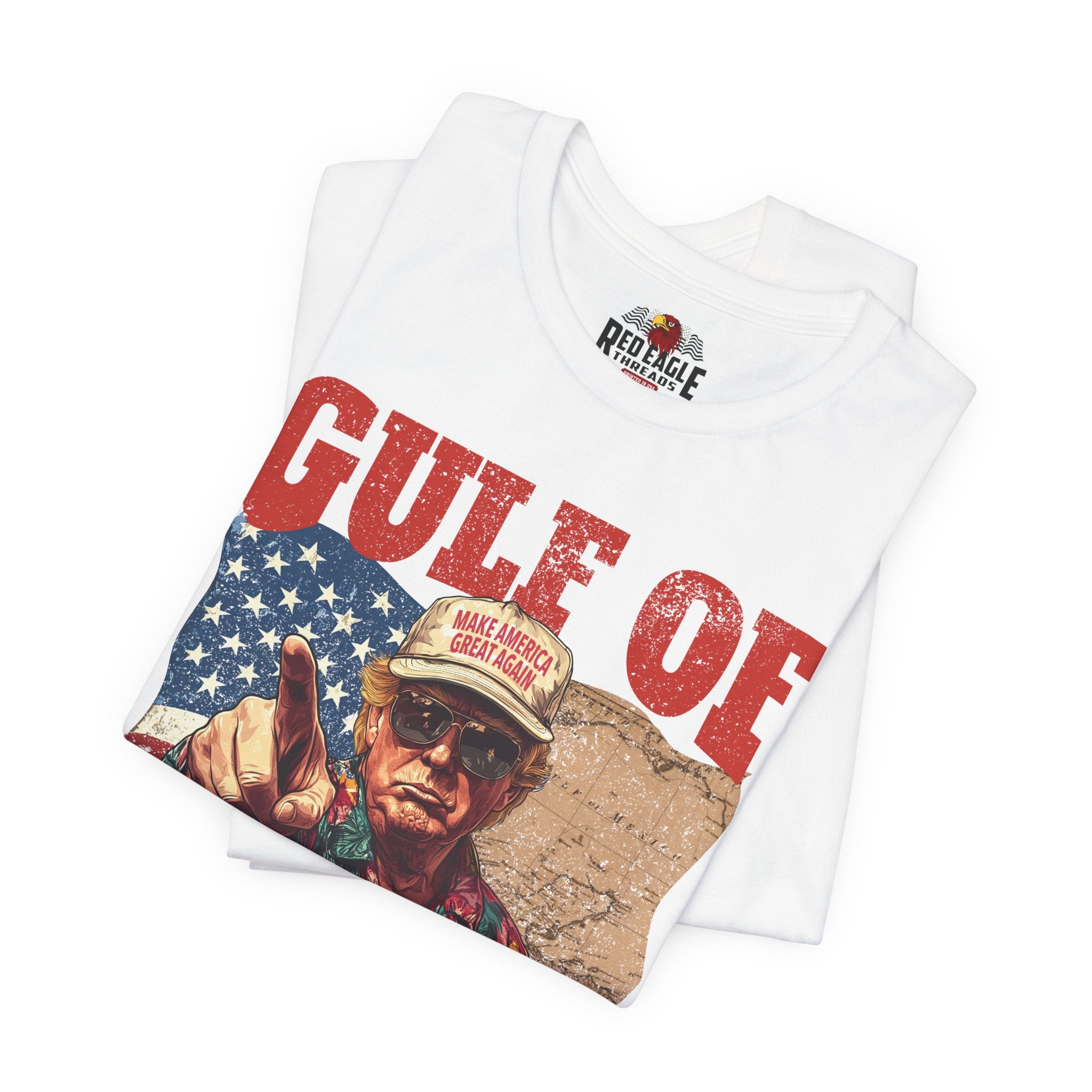 White t-shirt with graphic design featuring a person in a cap and sunglasses, with text and an American flag.