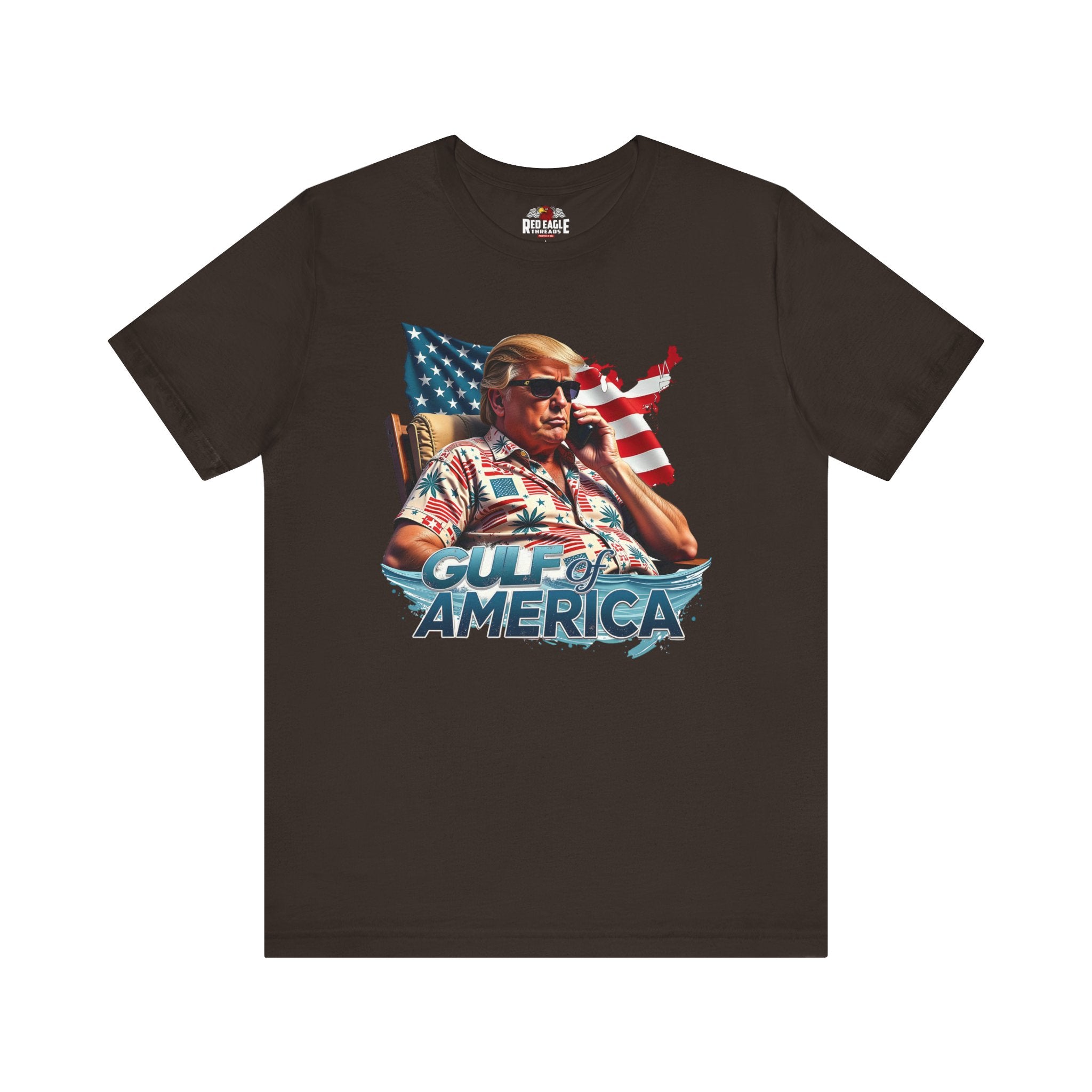 Brown t-shirt with graphic of a person on a phone with an American flag, sitting in a boat with 'Gulf of America' text.