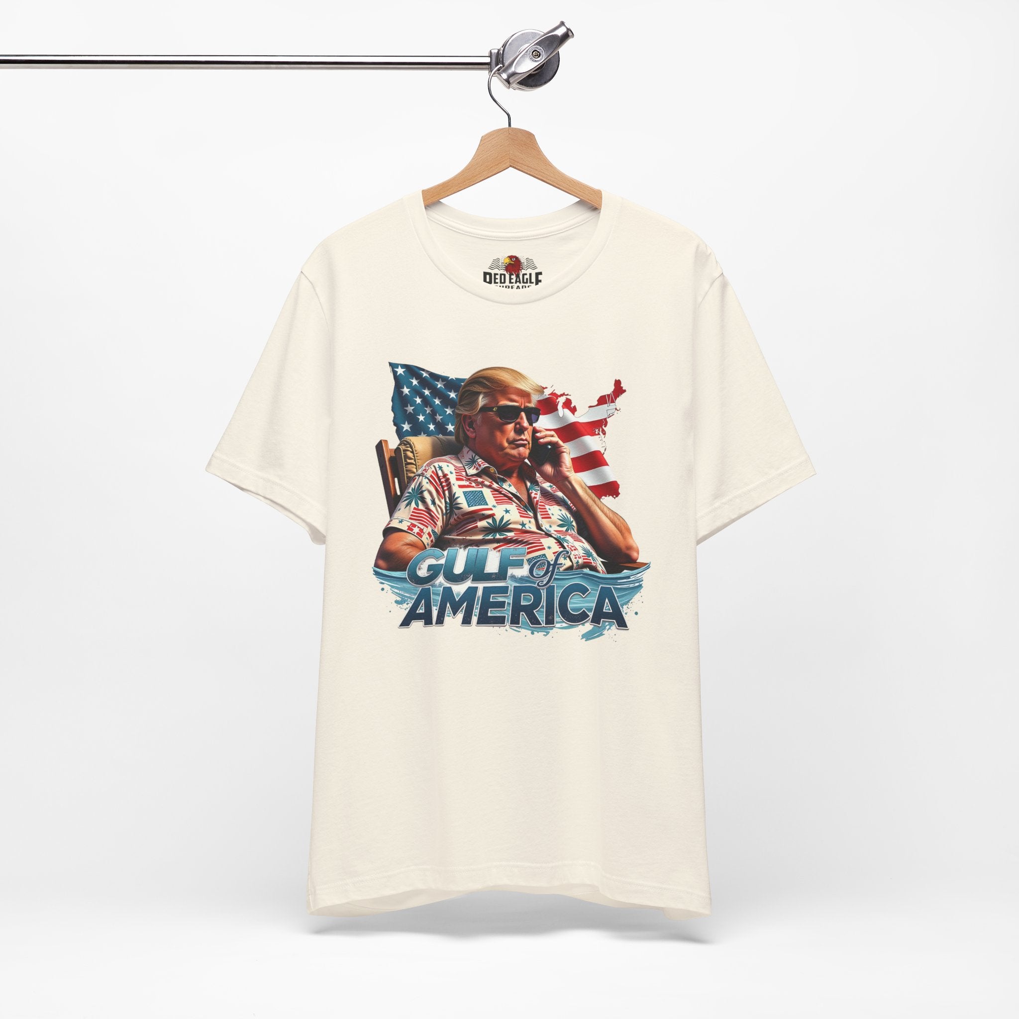 Natural t-shirt with graphic design on a hanger against a white background