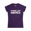 A purple short-sleeve t-shirt with the text 'I DOING LOVE AMERICA' printed in white across the chest, where the letter 'O' is replaced by a small American flag graphic. The shirt is displayed flat against a solid white background.