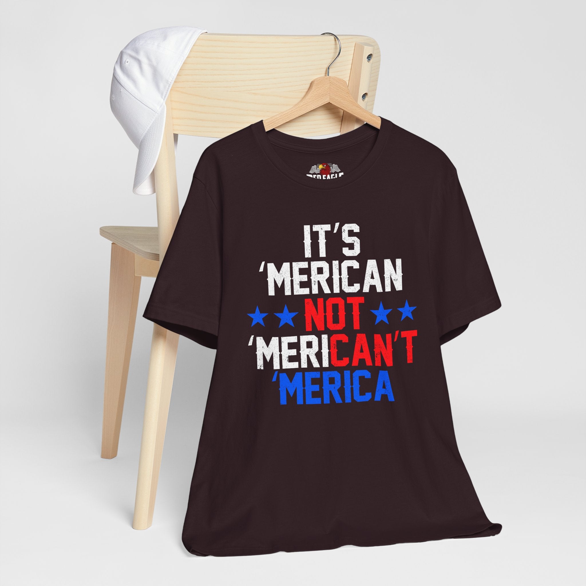 Oxblood Black t-shirt with humorous text design on a wooden chair against a white background
