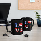 Two black mugs with 'LOVE' design on a desk with office items.