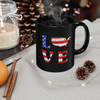 Black mug with 'LOVE' design featuring American flag colors on a table with decorative items.