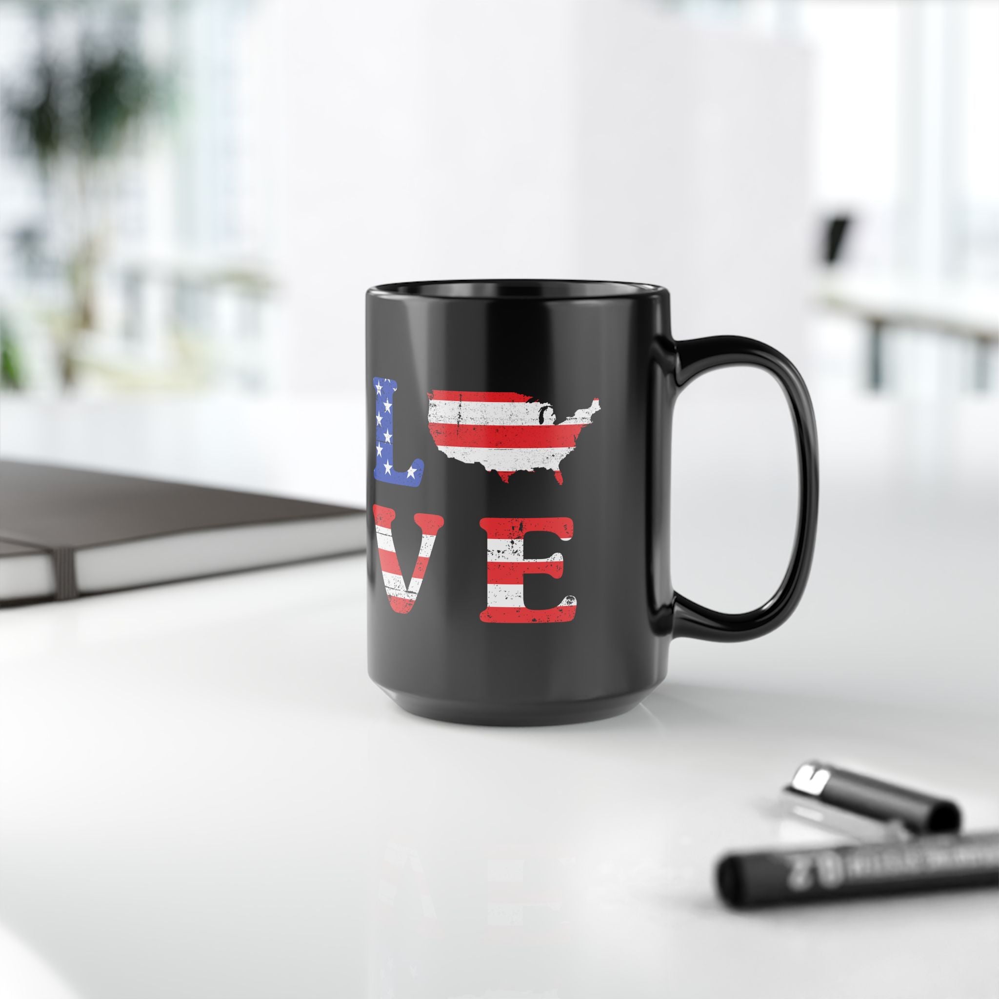 Black mug with 'LOVE' design featuring an American flag pattern on a white surface.