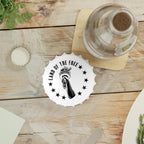 Table setting with white bottle opener fridge magnet with 'Land of the Free' logo on a wooden surface