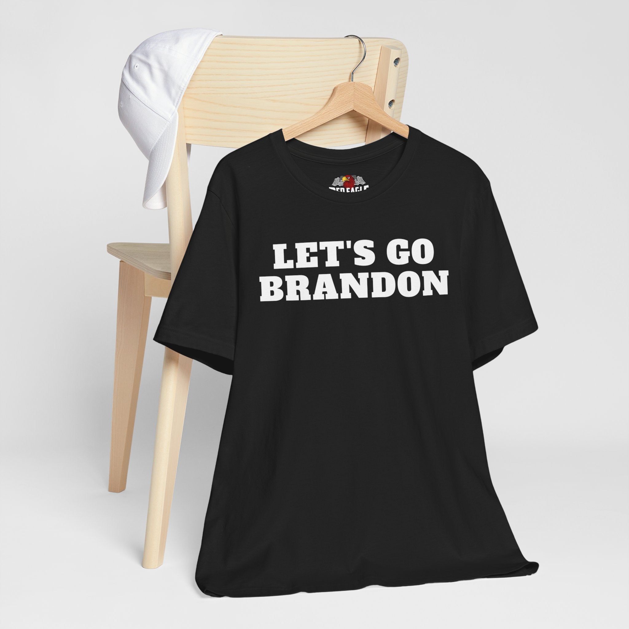 Black t-shirt with 'LET'S GO BRANDON' text on a hanger against a white background