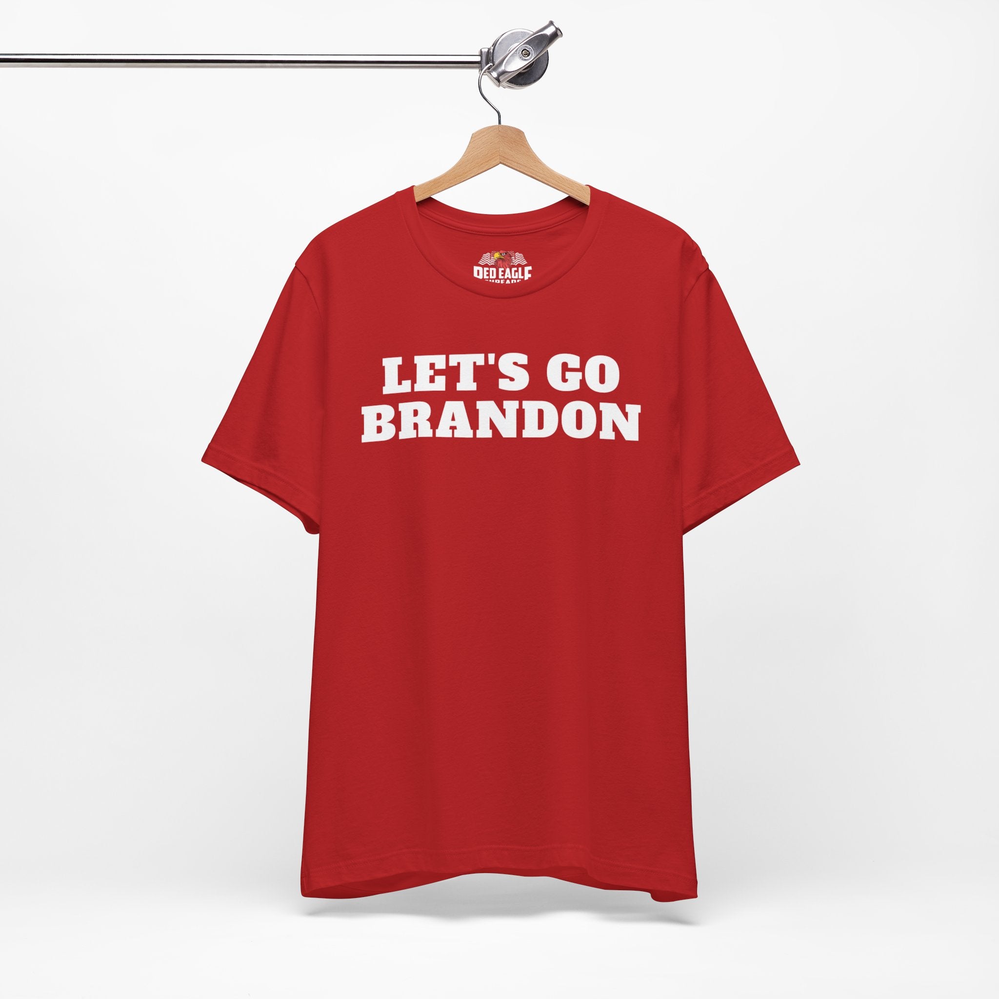 Red t-shirt with 'LET'S GO BRANDON' text on a hanger against a white background