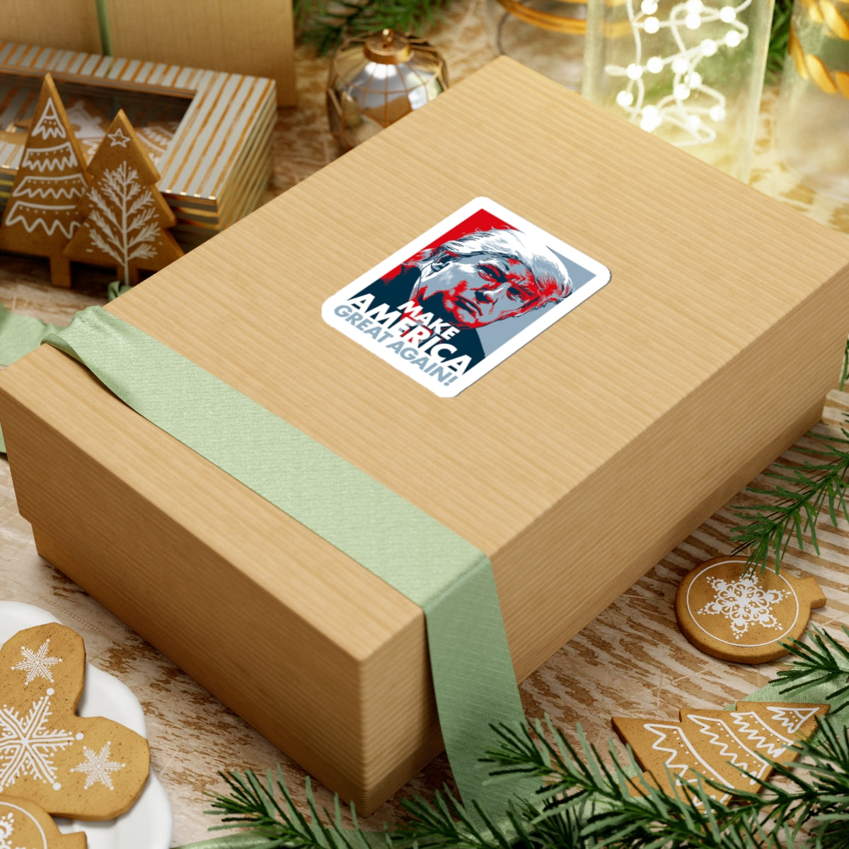 Gift box with a green ribbon and 'Make America Great Again' sticker on a festive background with cookies and decorations.