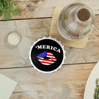 Bottle opener fridge magnet with 'MERICA' design on a wooden table with a bottle of water.
