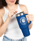 Person holding a blue travel mug with a logo and text on a white background