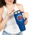 Person holding a blue travel mug with a logo and text on a white background