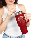 Person holding a red travel mug with a logo and text on a white background