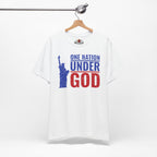 White t-shirt with 'One Nation Under God' graphic and Statue of Liberty on a hanger against a white background.