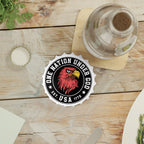 Table setting with a bottle opener fridge magnet with 'One Nation Under God' logo on a wooden table.