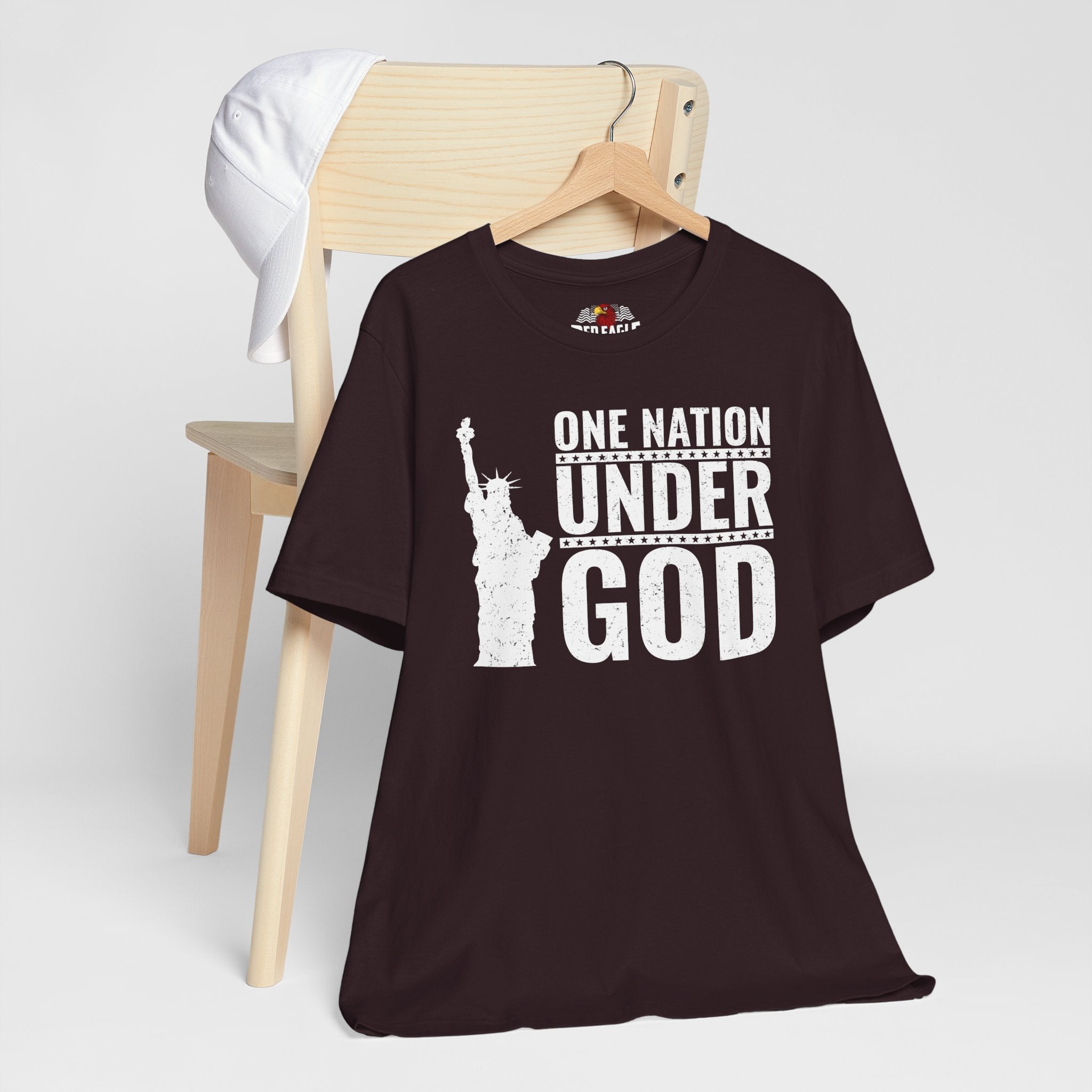Oxblood Black t-shirt with 'One Nation Under God' graphic on a hanger against a white background