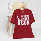 Red t-shirt with 'One Nation Under God' graphic on a wooden chair against a white background