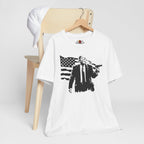 White t-shirt with graphic design on a wooden chair against a white background