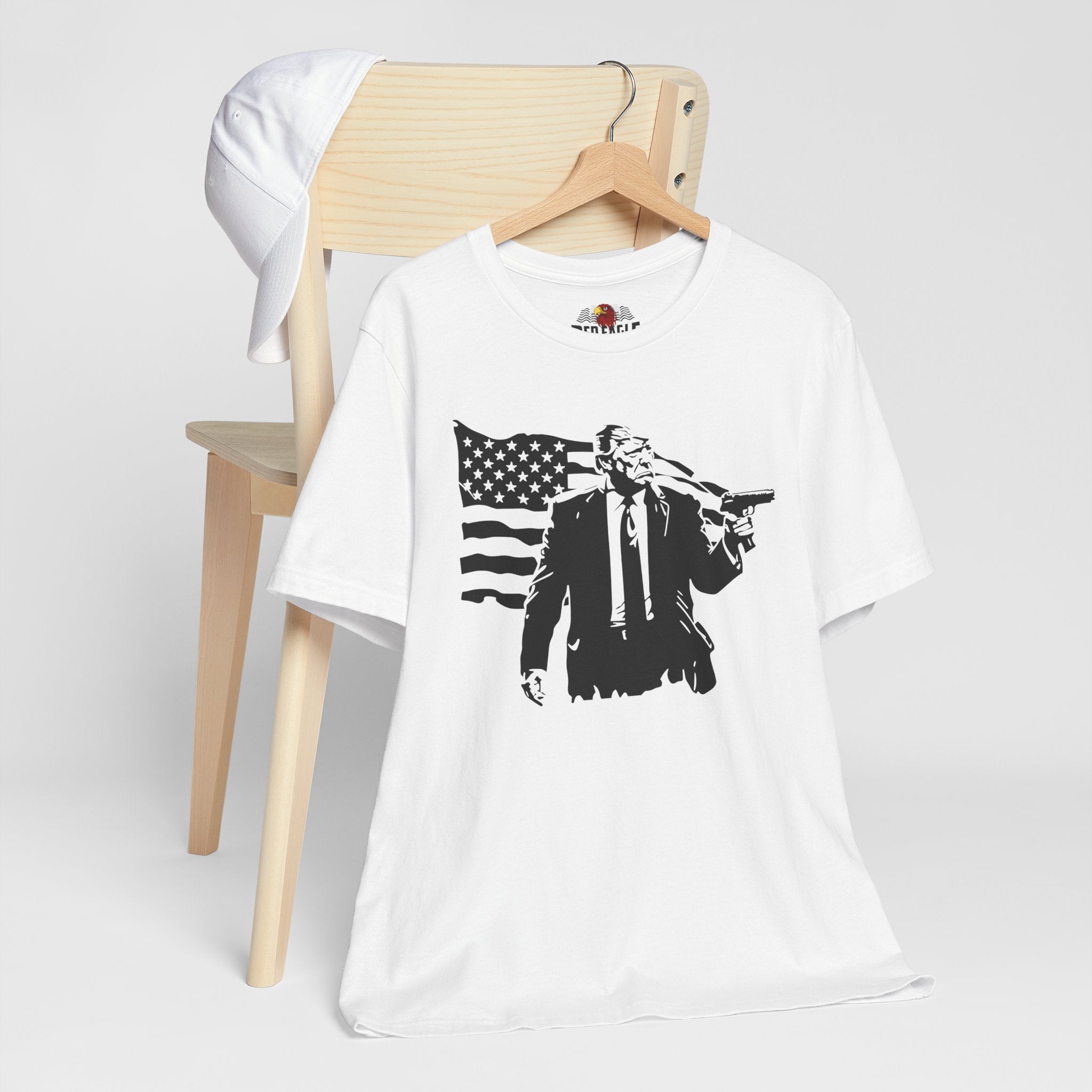 White t-shirt with graphic design on a wooden chair against a white background