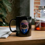 Black mug with a graphic design of a dog wearing sunglasses and a flag-themed bandana on a wooden surface.