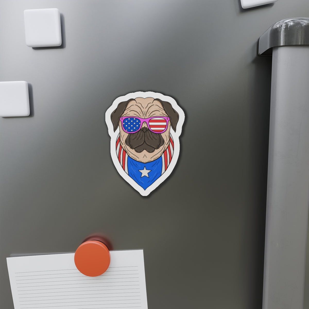 Fridge magnet of a pug wearing sunglasses with an American flag design on a metallic refrigerator.