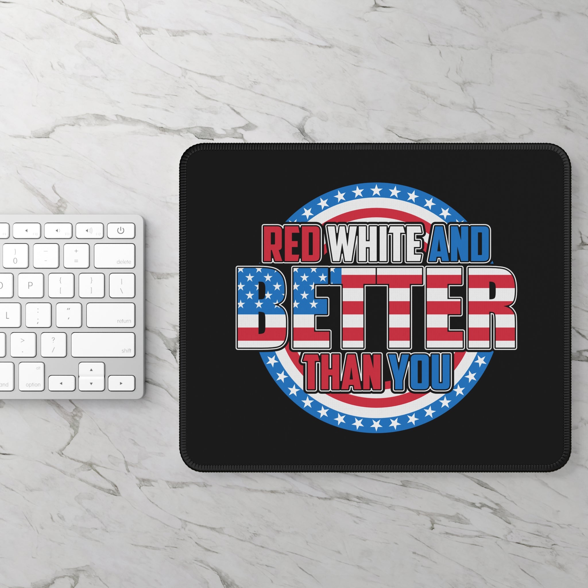 Black mouse pad with 'Red White and Better Than You' text on a marble surface with a keyboard.