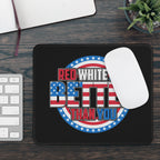 Mouse pad with American flag design and text on a desk with a keyboard and plant.