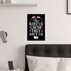 Wall art with text and American flags on a white wall above a bed.