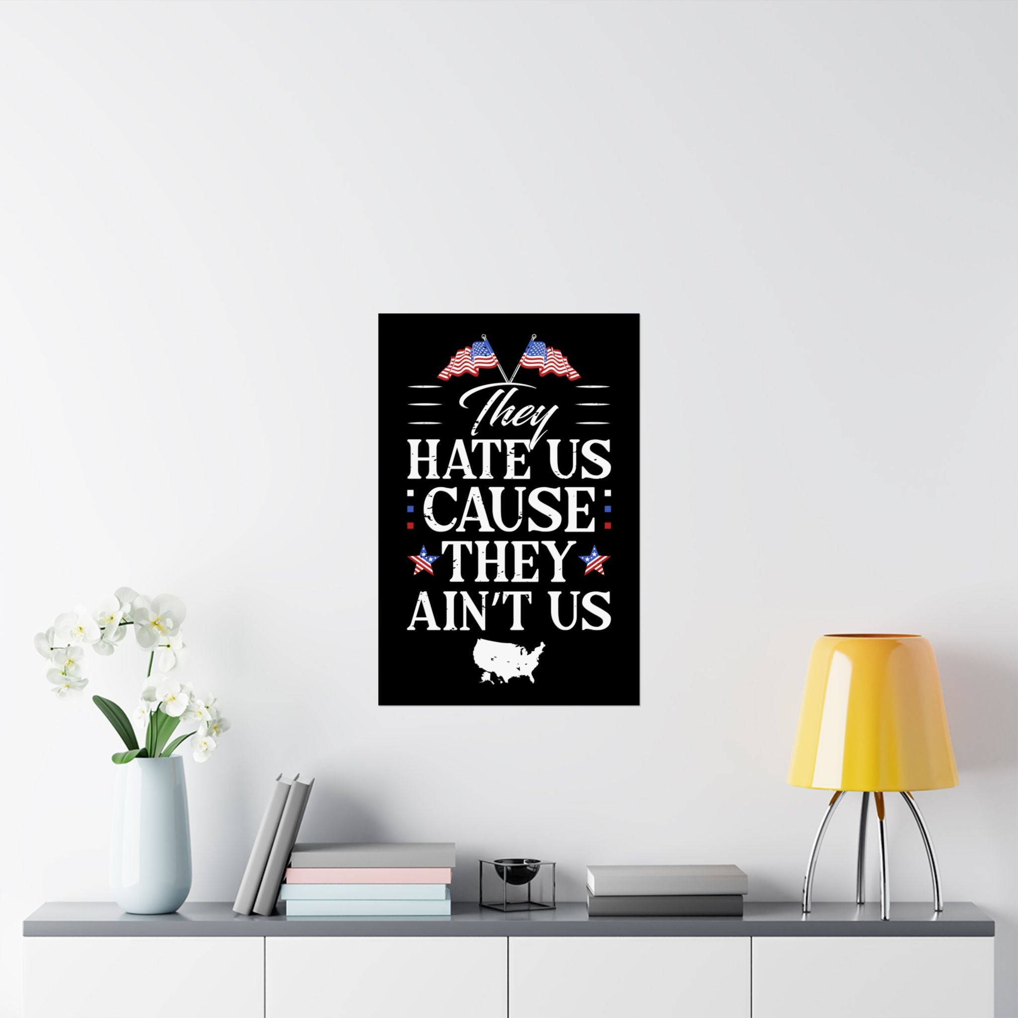 Framed poster with text and American flags on a wall above a shelf with decor items.
