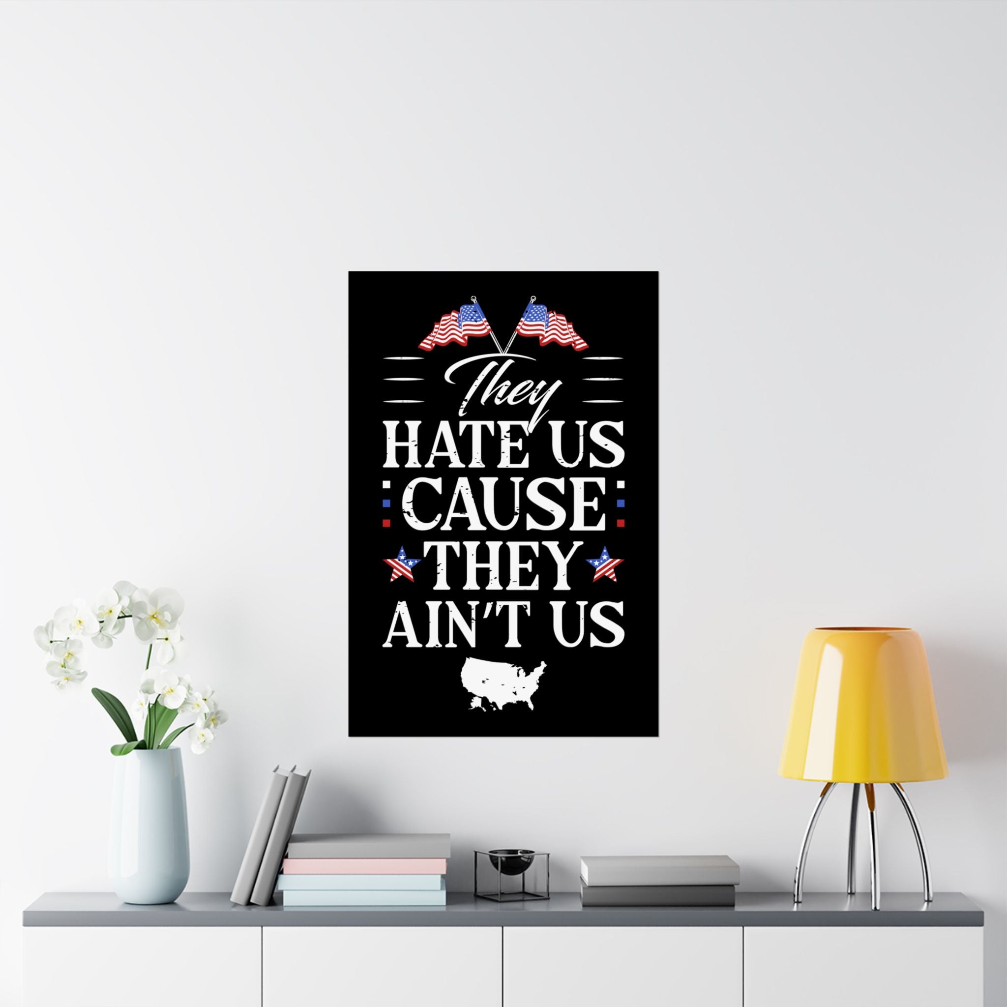Framed poster with text and American flags on a wall above a shelf with decor items.