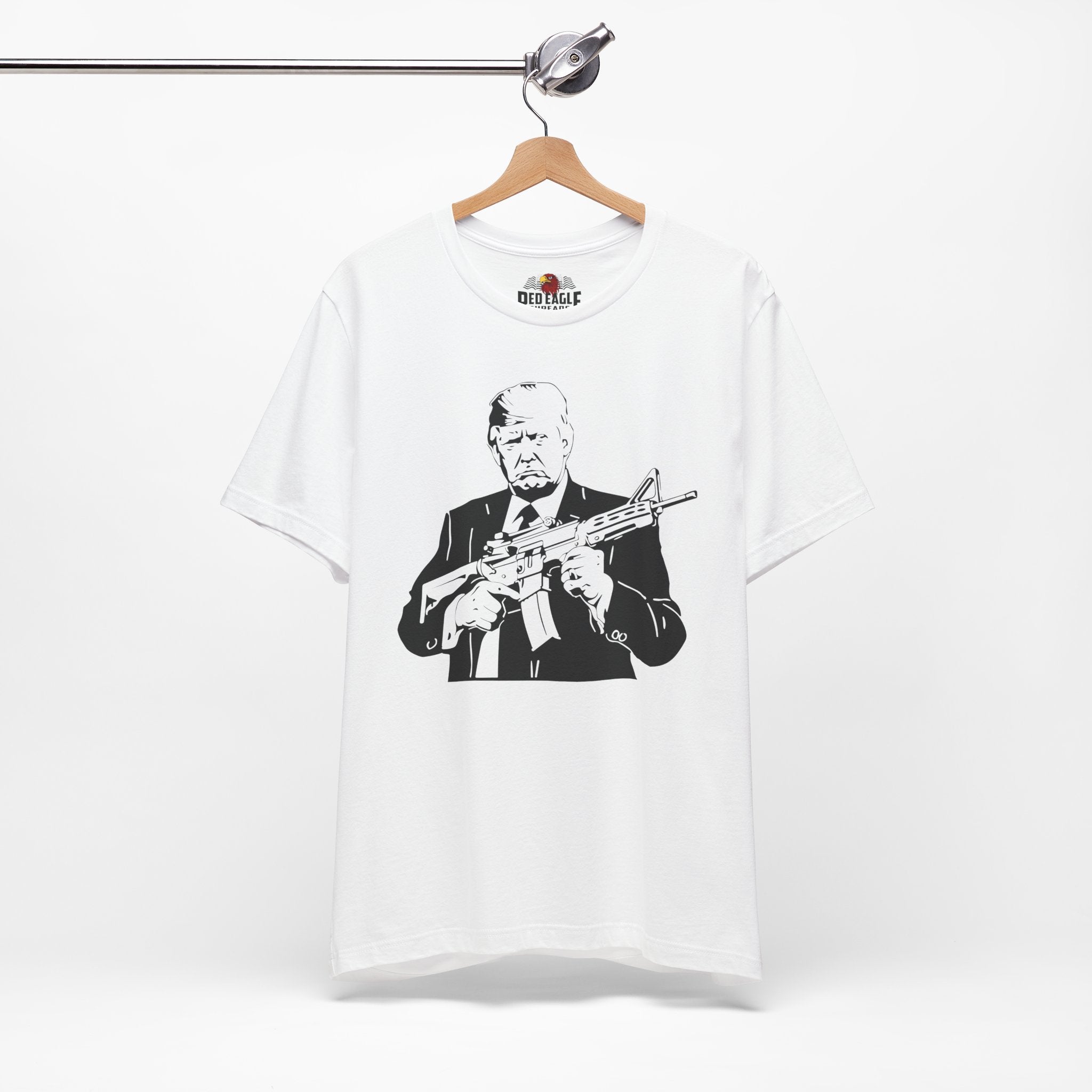 White t-shirt with graphic design of a person holding a rifle, displayed on a hanger against a white background.
