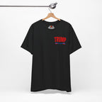 Black t-shirt with 'TRUMP' printed on the front, hanging on a wooden hanger against a white background.