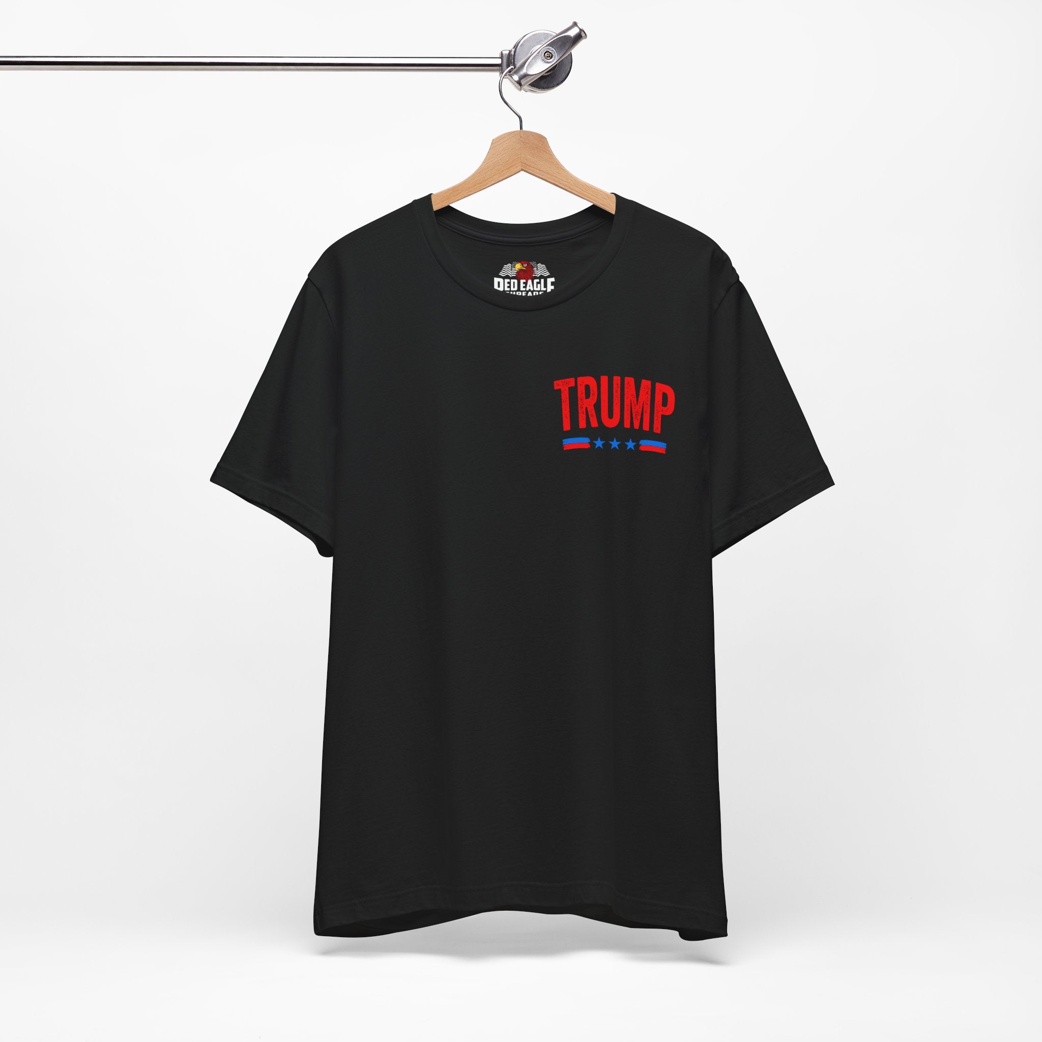 Black t-shirt with 'TRUMP' printed on the front, hanging on a wooden hanger against a white background.