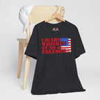 Vintage Black t-shirt with text and American flag design on a hanger against a white background