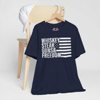 Navy blue t-shirt with 'Whiskey Steak Guns & Freedom' text and flag design on a wooden chair.