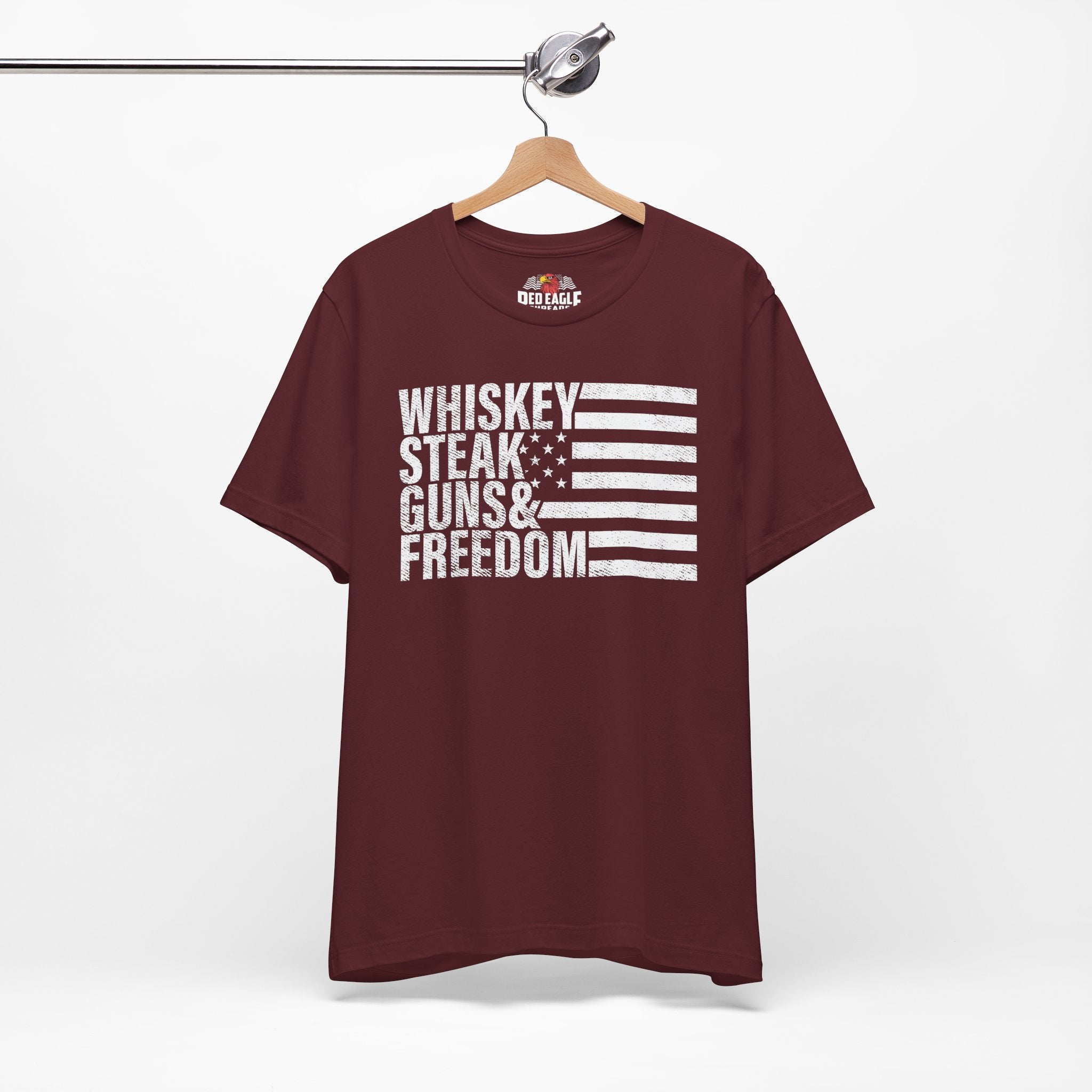 Maroon t-shirt with text and flag design on a hanger against a white background