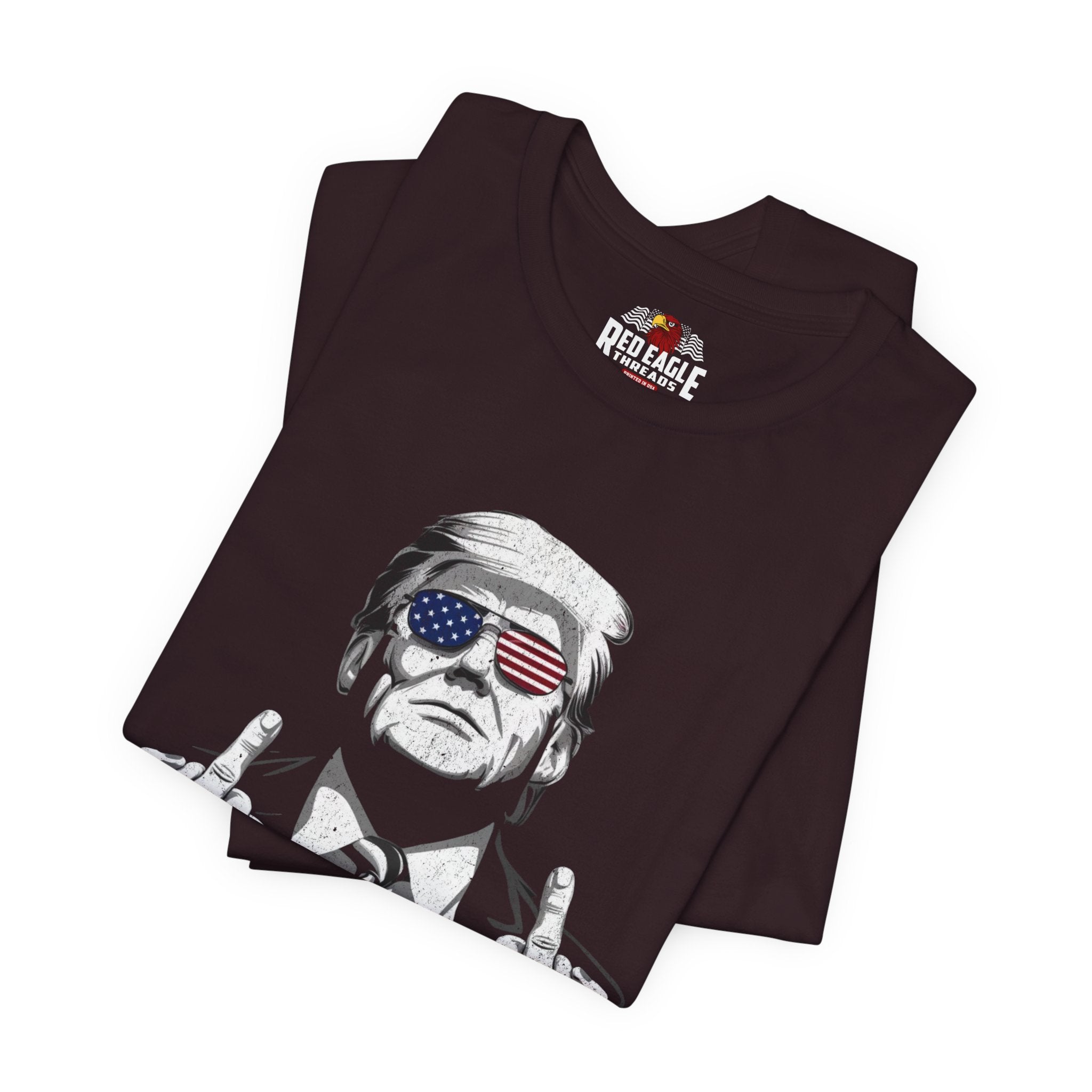 Oxblood Black t-shirt with graphic design of a person wearing sunglasses with American flag design, folded on a white background.