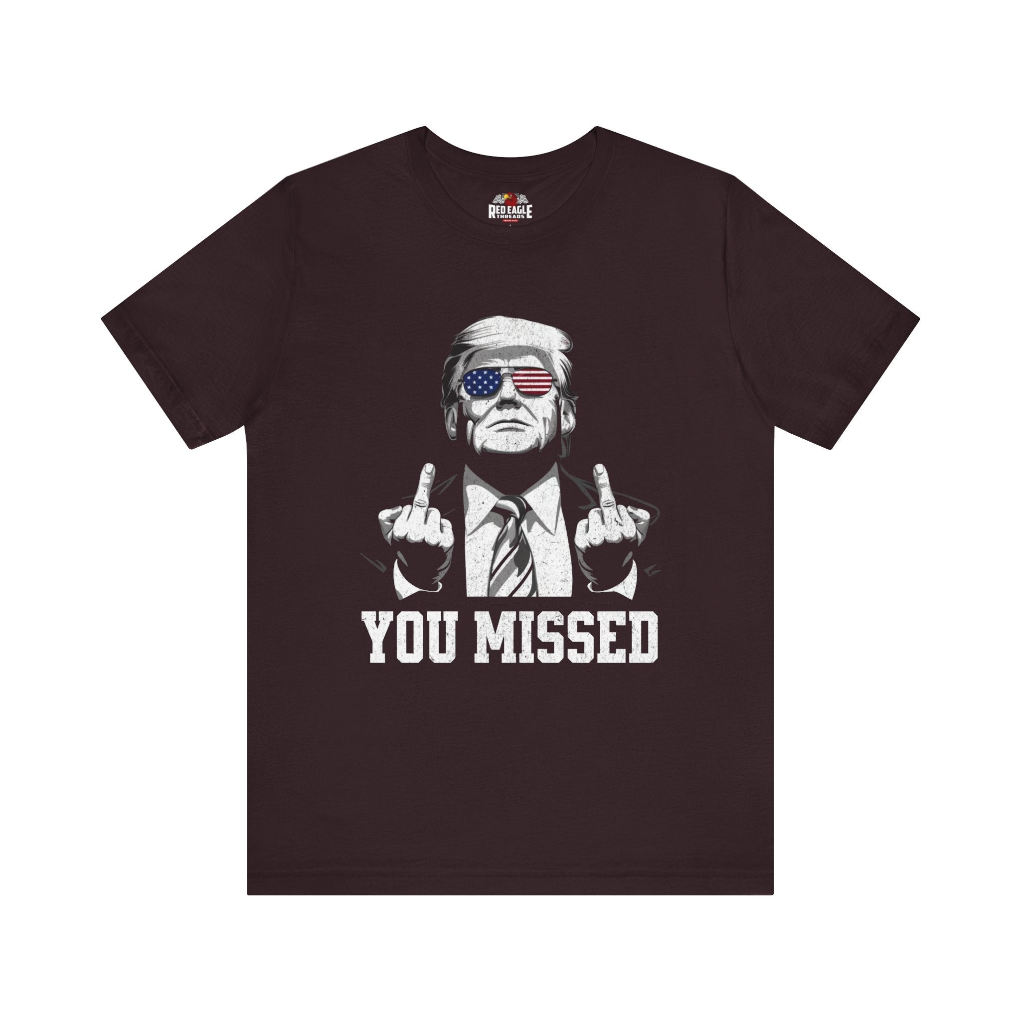 Oxblood Black t-shirt with graphic of a person giving the middle finger and text 'YOU MISSED' on a white background
